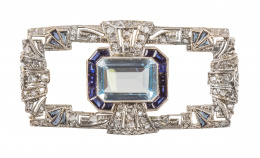 193.  Broche placa  rectangular estilo Art-Decó, con topacio azul central de talla esmeralda