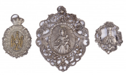 549.  Dos medallas y una placa de plata de cofradía, con la Virgen del Carmen, La Virgen del Prado y el Espíritu Santo.Trabajo español, S. XVIII-XIX.
