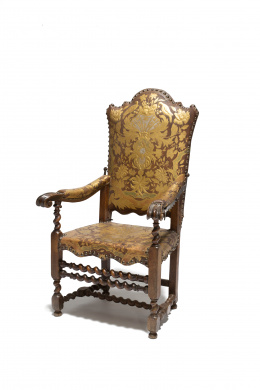543.  Sillón “Rocchetto” (Carrete)  de nogal, con balaustres torsos,  con cuero gofrado policromado, dorado y tachonado. Trabajo Italiano, S. XVIII.