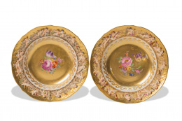 515.  Dos platos de porcelana esmaltada y dorada, con flores pintadas.Nápoles, S. XIX 