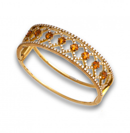 75.  Brazalete rígido de brillantes y citrinos en banda frontal calada que dibuja rombos.