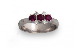 132.  Sortija tresillo de rubíes entre brillantes.