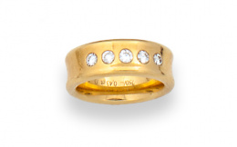 545.  Sortija cintillo de brillantes en montura ancha de oro amarillo de 18K