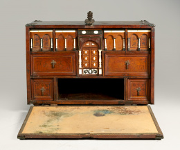 913.  Bargueño o papelera de madera de nogal, decorado con taracea de tema naturalista y columnas de hueso.Trabajo mejicano, S. XVII..