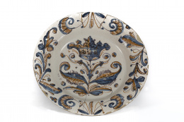 1039.  Plato de cerámica esmaltada de la serie tricolor con corona entre hojas y ramas.Talavera, S. XVII.