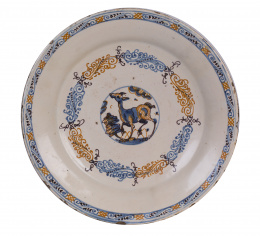 1055.  Plato de cerámica esmaltada de la serie tricolor con un cervatillo en el asiento.Talavera, S. XVII .