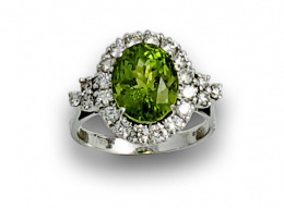 830.  Sortija rosetón de peridoto oval orlado de brillantes en oro blanco de 18K.