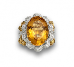 859.  Sortija con con cuarzo citrino oval en orla ondulada de brillantes,y con lazos de zafiros amarillos en los brazos de la montura.