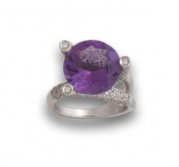669.  Sortija con amatista redonda rodeada por  tres brazos de brillantes,en oro blanco de 18K.