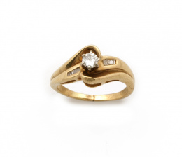 695.  Sortija de brillante central y baguettes a ambos lados en oro amarillo de 14 K.