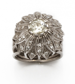 178.  Sortija flor con brillante de 0,90 ct aprox de talla antigua  rodeado  de pétalos con brillantes, en montura de platino.