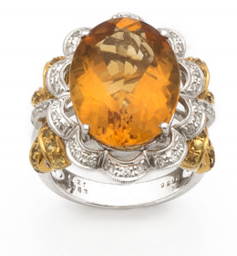 672.  Sortija con cuarzo citrino oval orlado de brillantes en ondas y lazos de zafiros amarillos.