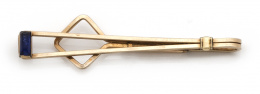 730.  Barra de corbata KREMENTZ con vidrio azul rectangular en el extremo; en metal dorado.