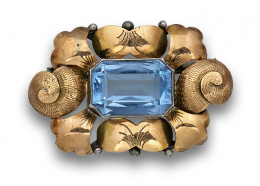 555.  Broche Art-Decó catalán con vidrio azul y marco con pétalos en plata dorada.