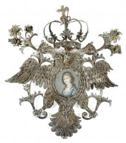 216.  ESCUELA ESPAÑOLA,  PP. SIGLO XIXRetrato de dama en una medalla devocional con águila bicéfala coronada y tembladeras de flores en filigrana de plata.