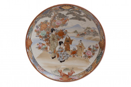 1101.  Plato de porcelana esmaltada con personajes en asiento, en una paisaje, esmaltado en dorado.Japón, ffs. del S. XIX