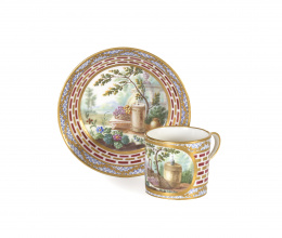 1083.  Plato y taza de porcelana esmaltada y dorada, decorado con cartelas de escenas de una jardín.Francia, S. XIX.