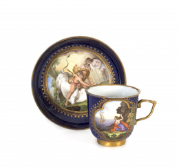 1092.  Taza y plato de porcelana esmaltada en azul y dorado con reservas.Sajonia, S. XVIII..