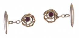 82.  Gemelos circulares de pp. S. XX en forma de flor calada con granate central