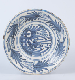 1159.  Plato de cerámica esmaltada en azul cobalto de la serie de la golondrina, con lañas.Talavera, S. XVII