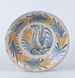 1157.  Plato de cerámica esmlatada la serie de la golondrina en azul cobalto y naranja, con lañas.Talavera, S. XVIII