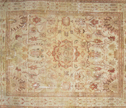 624.  Alfombra persa de fondo claro y dibujos vegetales en ocre y rojizo, h. 1900