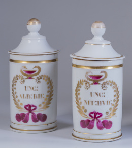 639.  Pareja de botes de farmacia en porcelana, con cartela en dorado y esmaltada en rosa.Francia, S. XIX.