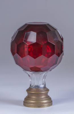 1254.  Remate de escalera en cristal granate facetado, con base de metal, pp. del S. XX.