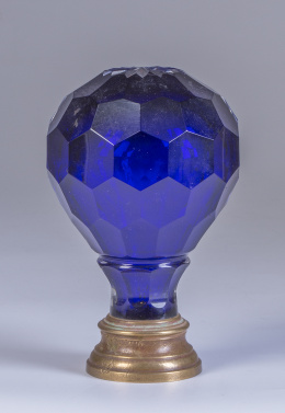 1255.  Remate de escalera en cristal azul facetado, con base de metal, pp. del S. XX.