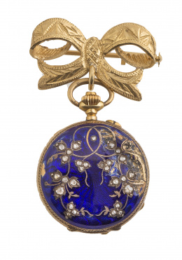 60.  Reloj saboneta de pp. S. XX en oro de 18K con esmalte azul y diamantes que pende de broche en forma de lazo