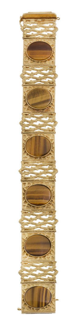 136.  Brazalete años 70 en forma de banda, con ojo de tigre oval como centro de seis piezas rectangulares de base en relieve