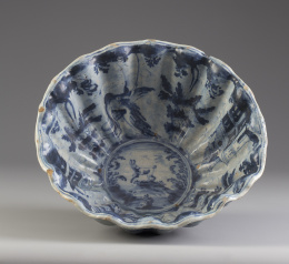 538.  Cuenco gallonado de cerámica esmaltada de la serie azul con decoración de aves y conejo en el asiento y árboles de pisos.Talavera, S. XVII.