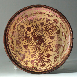 1157.  Plato acuencado de cerámica esmaltada de reflejo metálico, de la serie de las “clavelinas”.Manises, S. XVIII..