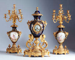 517.  Guarnición formada por reloj y pareja de candelabros en porcelana y bronce dorado.Francia, S. XIX