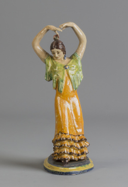 1111.  Gitana de cerámica esmaltada, con traje naranja.Triana, pp. del S. XX.