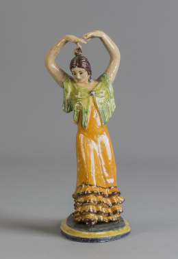 1111.  Gitana de cerámica esmaltada, con traje naranja.Triana, pp. del S. XX.