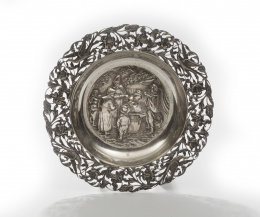 1260.  Bandeja de plata con escena holandesa de mercado, alero calado con hojas, flores y pájaros, pp. del S. XX.