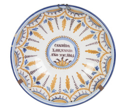 426.  Plato de cerámica con nombre "Cándida Lorenzio 1865" y decoración de pabellones, esmaltada en ocre y manganeso.Talavera, 1865.