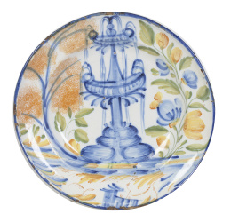 425.  Plato de cerámica esmaltada en azul cobalto y ocre con fuente rodeada por hojas.Manises, S. XIX