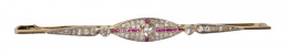 82.  Broche barra Art-Decó con diamantes y rubíes calibrados en forma ojival central y puntas de flecha laterales