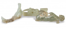 1044.  Tres jades tallados, uno con forma de dragón, otro con forma de pez con alga y otro con forma de balsa.Trabajo chino, S. XIX-XX 