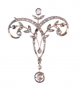 21.  Broche de diamantes Belle Epoque con diseño simétrico de ramas entre cintas, y brillante en chatón colgante.