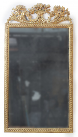604.  Espejo Carlos IV en madera tallada y dorada decorado con guillocas y rematado por hojas.Trabajo español, ff. del S. XVIII.