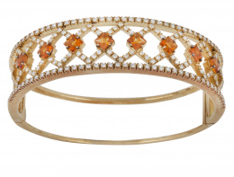 273.  Brazalete rígido de brillantes y citrinos en banda frontal calada que dibuja rombos.