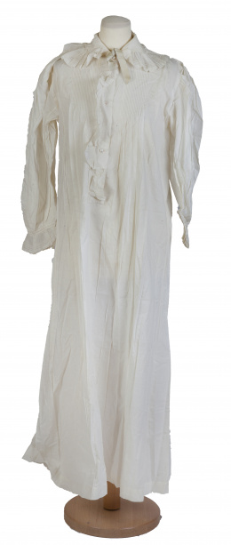 968.  Camisón de hilo blanco con chorreras, encaje en los pulos, lazovrde en el cuello y una B bordada bajo corona de marqués, pp. del S. XX.