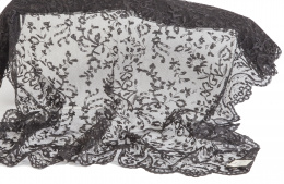 979.  Tapete de forma rectangular bordado de chantilly con motivos florales en encaje negro, S. XX.