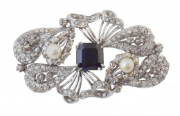 74.   Broche placa años 30 con diamantes y un zafiro sintético central flanqueado por dos perlas