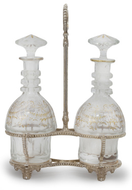 956.  Vinagrera en metal plateado con recipientes de cristal tallado con decoración dorada.