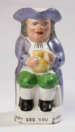 1097.  "Toby-jug" en cerámica esmaltada, con la leyenda "Tarry ere you Marry"Inglaterra, S. XIX.