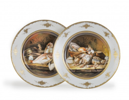 1049.  Pareja de platos de porcelana con escenas de bodegón.Alemania, h. 1900.Con marca en el reverso: NymphenburgFirmados: R. Apánúm.
